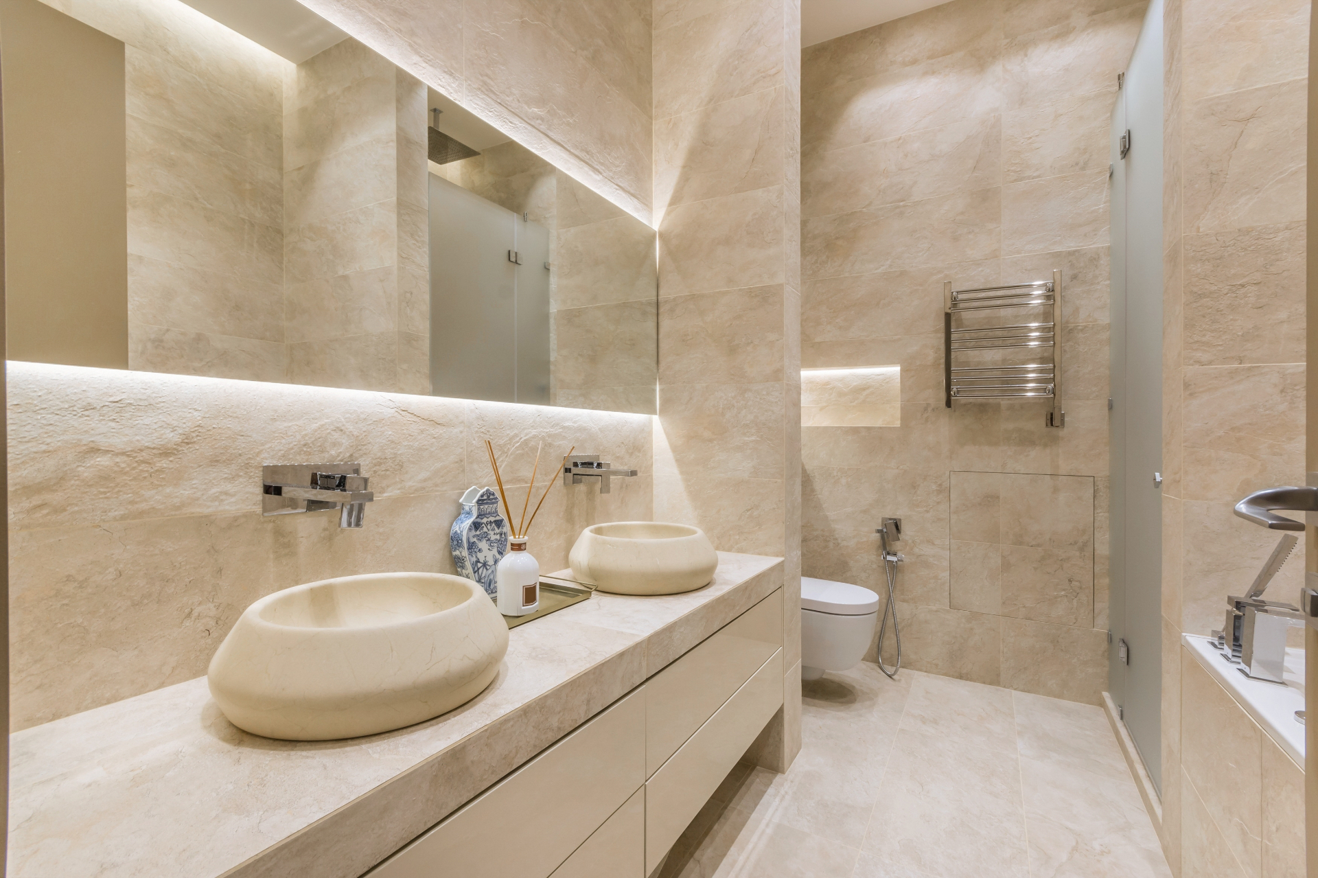 Luxury Spa Bathroom — Elegant bathroom featuring natural stone, vessel sinks, and warm ambient lighting throughout.